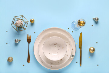 Elegant holiday table setting with gold cutlery and ornaments on light blue background for festive celebrations, festive christmas and new year ornaments © Pixel-Shot