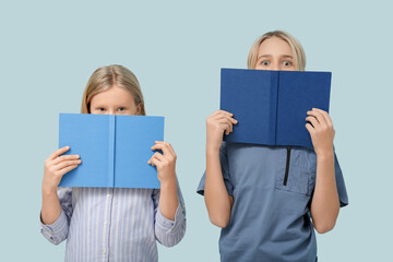 Naklejka premium Cute little children with books on blue background