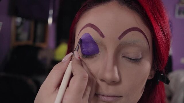 Professional Makeup Artist Applying Character Makeup on Redhead Woman &ndash; Close-up. Maquilladora Profesional Aplicando Maquillaje de Caracterizaci&oacute;n a Mujer Pelirroja &ndash; Primer Plano
