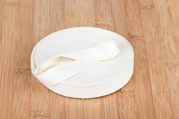 Taffeta tape made of thick cotton fabric on a wooden surface.