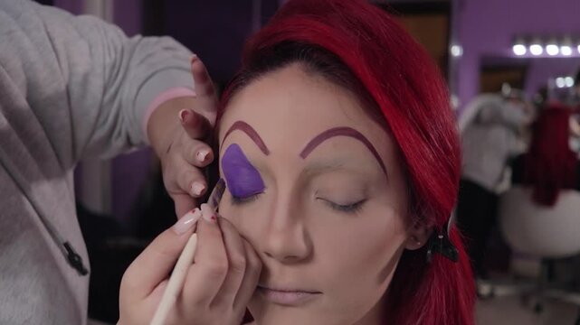 Professional Makeup Artist Applying Character Makeup on Redhead Woman &ndash; Close-up. Maquilladora Profesional Aplicando Maquillaje de Caracterizaci&oacute;n a Mujer Pelirroja &ndash; Primer Plano

