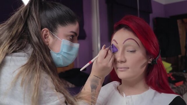 Professional Makeup Artist Applying Character Makeup on Redhead Woman &ndash; Close-up. Maquilladora Profesional Aplicando Maquillaje de Caracterizaci&oacute;n a Mujer Pelirroja &ndash; Primer Plano
