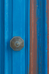 Detail of a blue door with a knob, close up.
