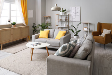 Interior of living room with sofas, commode and curtains on window
