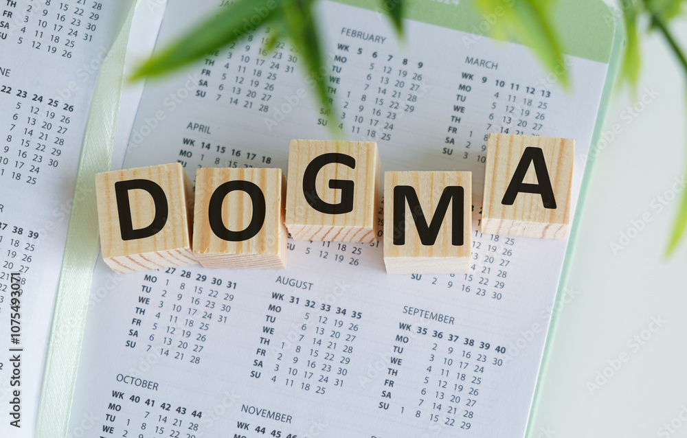 Poster dogma text on the wooden block with notebooks, keyboard with chart