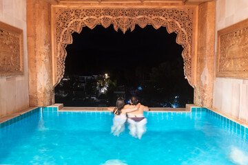 Mother and daughter relax in a private pool while enjoying a stunning scenic view during a blissful evening, Koh Chang, Thailand