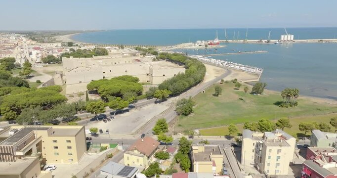 Aerial view of the castle located in Barletta, Puglia, Italy. It was a medieval fortress built on the coast of the Mediterranean Sea. Today it's a museum. In the background is the port of the town.