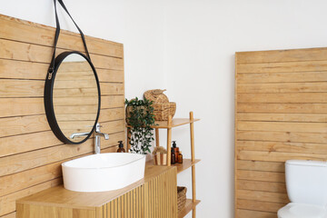 Interior of restroom with sink, mirror and shelf unit