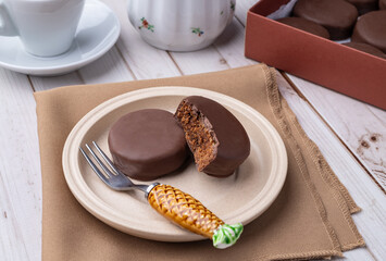 Brazilian Pao de Mel or chocolate covered honey cookies over a wooden table