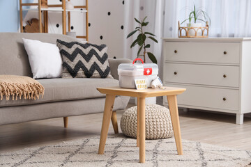 First aid kit with pills on table in living room interior