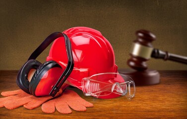 Hammer judge wood gavel with helmet hat on wooden table.