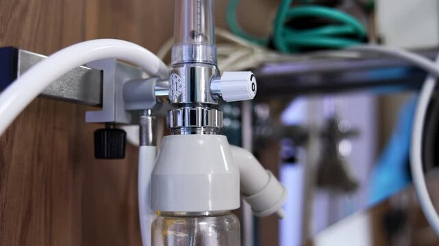 Medical oxygen cylinder hanging on the wall. Hospital emergency oxygen flowmeter with tubes. Close up.