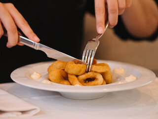a woman eating a plate of fried squid