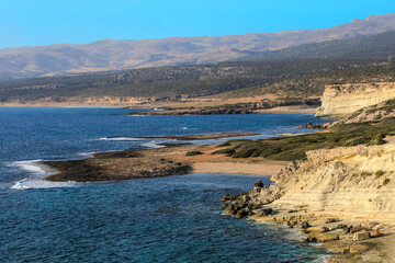 Küstenverlauf mit Sandstrand und helle Felsen aus Kalkstein