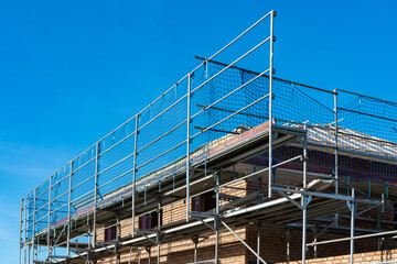 Construction scaffolding on a building under bright blue sky