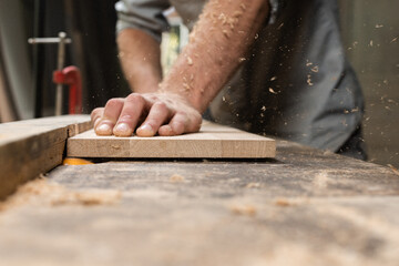 A carpenter is milling a board from home on a homemade machine © alexeyborodin