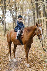 Obraz premium Young girl rides a horse in the forest.
