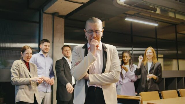 A bald woman faces bullying and harassment from coworkers in a tense office scene, enduring cruel remarks and paper throws, highlighting workplace discrimination.