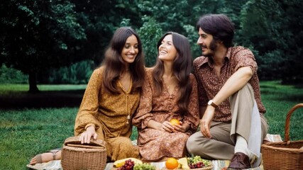 Group of friends enjoying a picnic outdoors, dressed in vintage 1970s fashion, evoking a nostalgic atmosphere of leisure and companionship