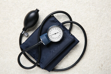 Blood pressure measuring device on light textured background, top view