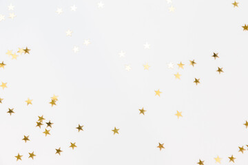 Gold sparkle confetti stars on a white background. Glitter, shine, bright. Christmas festive flat...