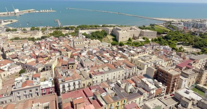 Aerial view of the castle and the Basilica of Santa Maria Maggiore, cathedral of the town of Barletta, Puglia, Italy. In background is the Mediterranean seaport of the city. 