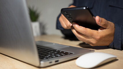 Programmer using smartphone and laptop for cybersecurity and data protection