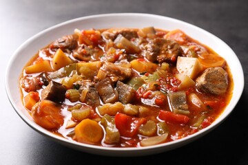 Delicious stew with vegetables in bowl on table, closeup