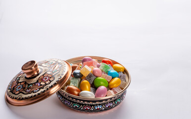 Colorful almond candies in the stylish,crystal candy bowl on white with copy space.The Sugar Feast concept. (Turkish name; Ramadan - Ramazan bayrami, Seker bayrami)
