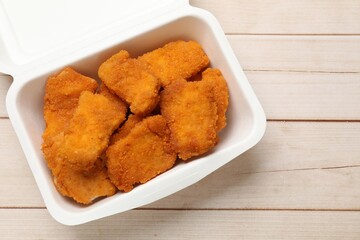 Tasty chicken nuggets on wooden table, top view. Space for text