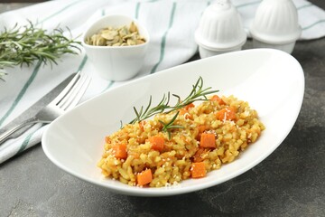 Delicious pumpkin risotto served on grey table, closeup