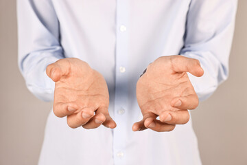 Man holding something on grey background, closeup