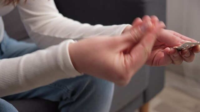 Close up of young woman opening birth control pills, holding hormonal oral contraceptive medicine, take pharmaceutical to prevention, safe virus sex disease. Contraception and pregnancy concept