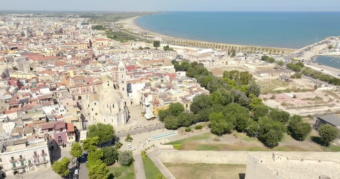 Aerial view of the castle and the Basilica of Santa Maria Maggiore, cathedral of the town of Barletta, Puglia, Italy. In background is the Mediterranean seaport of the city. 