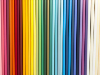 A row of colorful fabric rolls, each with a different color