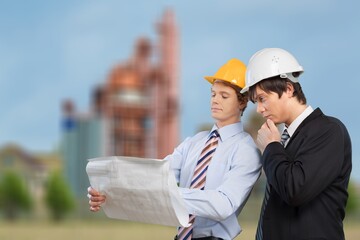 Engineers examining survey standing industrial facility