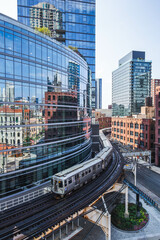 Modern Chicago L Train on elevated railway  passing through downtown Loop district with curved...