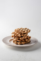 Homemade waffles stack on white plate isolated on white background, copy space