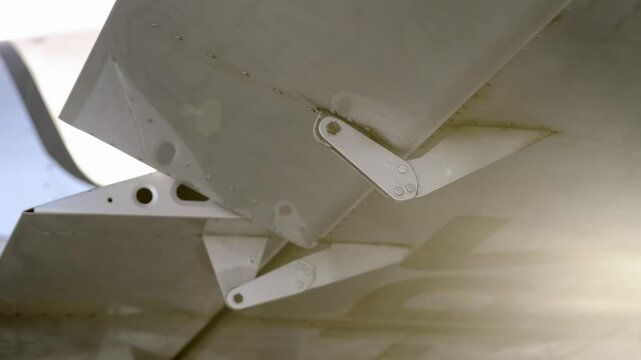 Closeup of fraise and differential type aileron on the wing of lightweight aircraft. Checking the aircraft controls before take-off or after maintenance. Operation of airplanes aileron check.