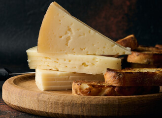 Triangular pieces of cheese on a wooden board
