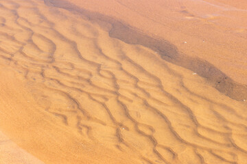 Looking into a small depression on the beach within Kohler-Andrae State Park, Sheboygan, Wisconsin filled with the washing waves of Lake Michigan in early November