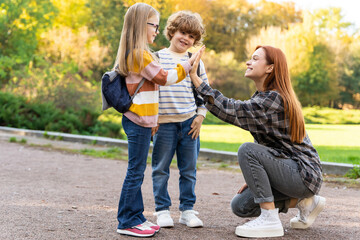 Fototapeta premium Kids and female teacher outdoors resting promoting social attitudes of friendship and teamwork