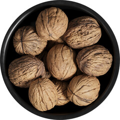 Top view of dark bowl with bunch of walnuts