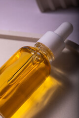 Cosmetic or medical bottle with pipette. Gold liquid product in glass bottle with dropper. Beauty concept.