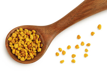 Bee pollen grains in wooden spoon isolated on white background. Top view. Flat lay