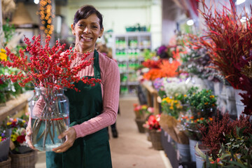 Portrait of a confident latin american female florist making a Christmas flower arrangement in a store