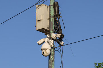 A camera is mounted on a tall pole, set against a beautiful blue sky, creating a striking visual...