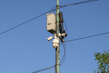 A camera mounted securely to a tall pole with a clear blue sky beautifully spread out in the...
