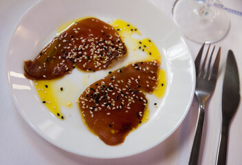 Traditional Andalusian seafood dish Atun de almadraba - raw sliced red tuna fish with sauce