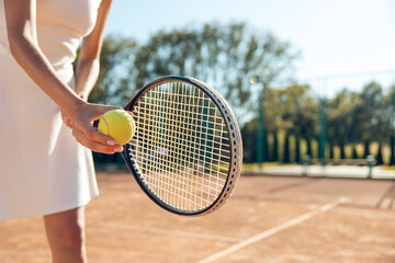 Female tennis player in white clothes exercising on the tennis courts